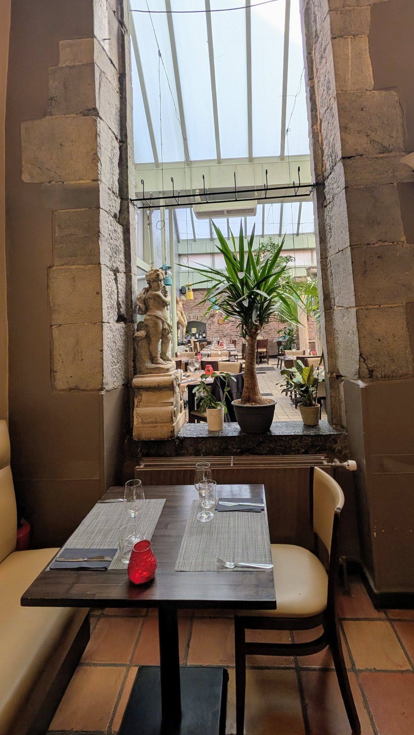 Une table près de la verrière, entre pierre et plantes