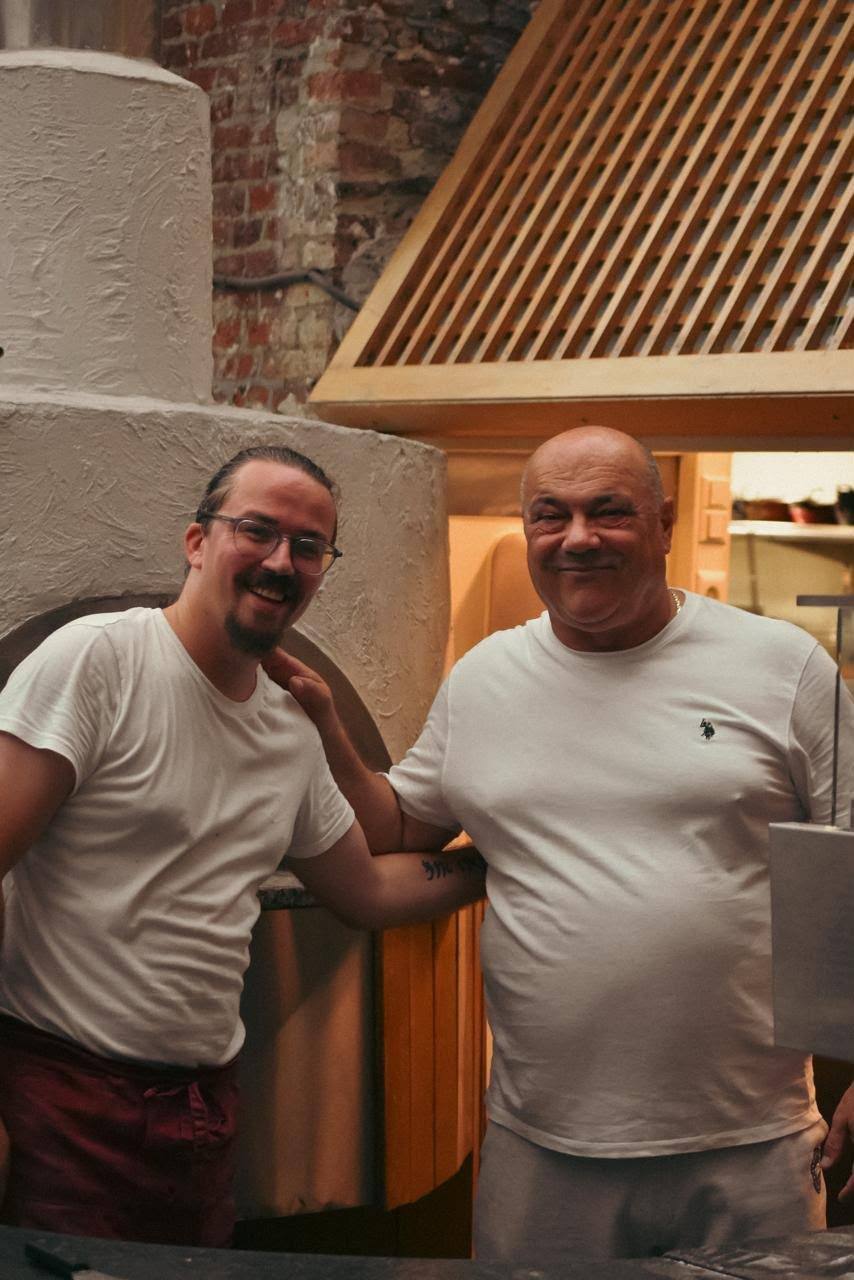 L'équipe en cuisine, devant le four à pizza
