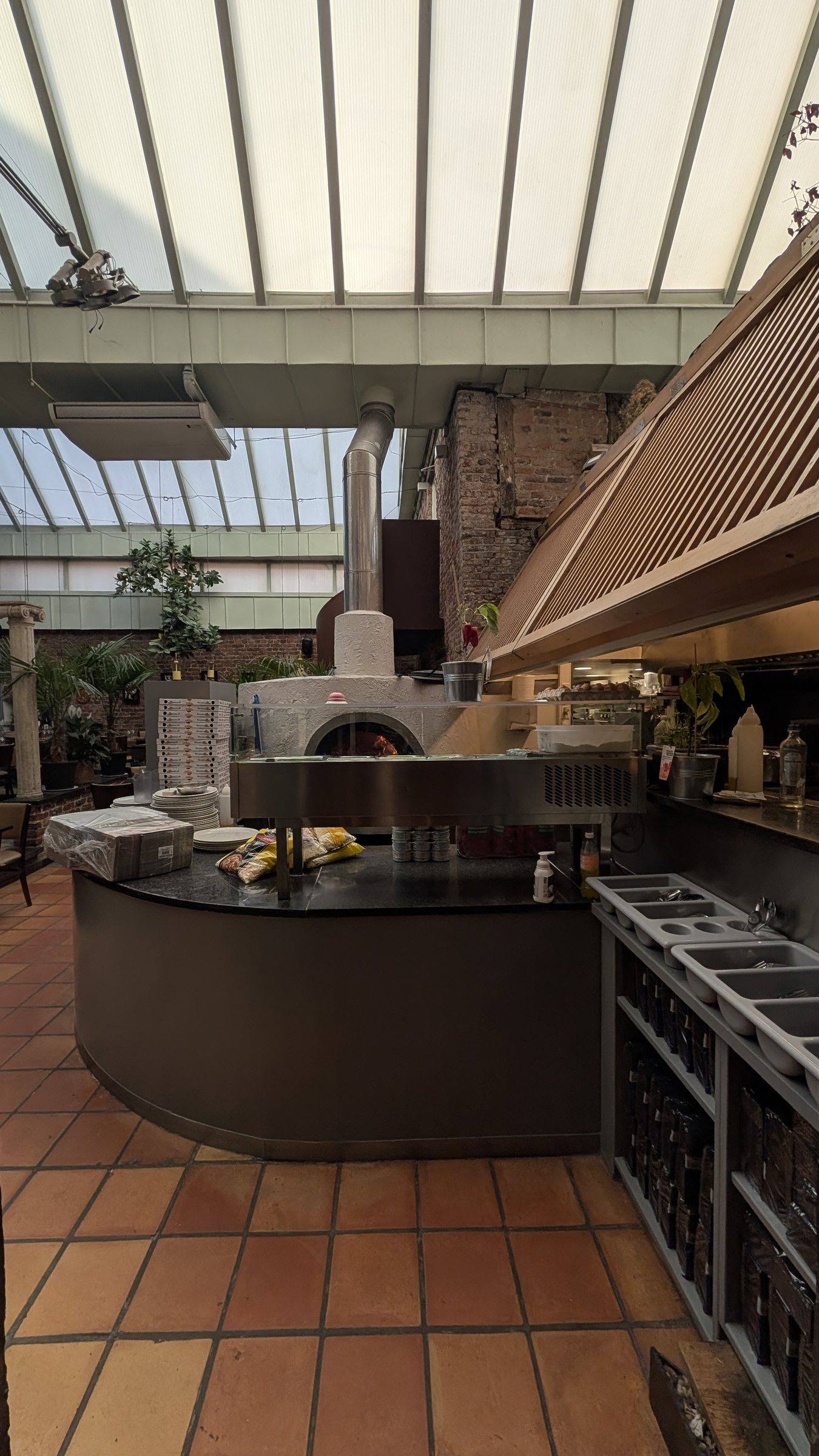 Le comptoir et le four à pizza d'I Giardini, sous la verrière