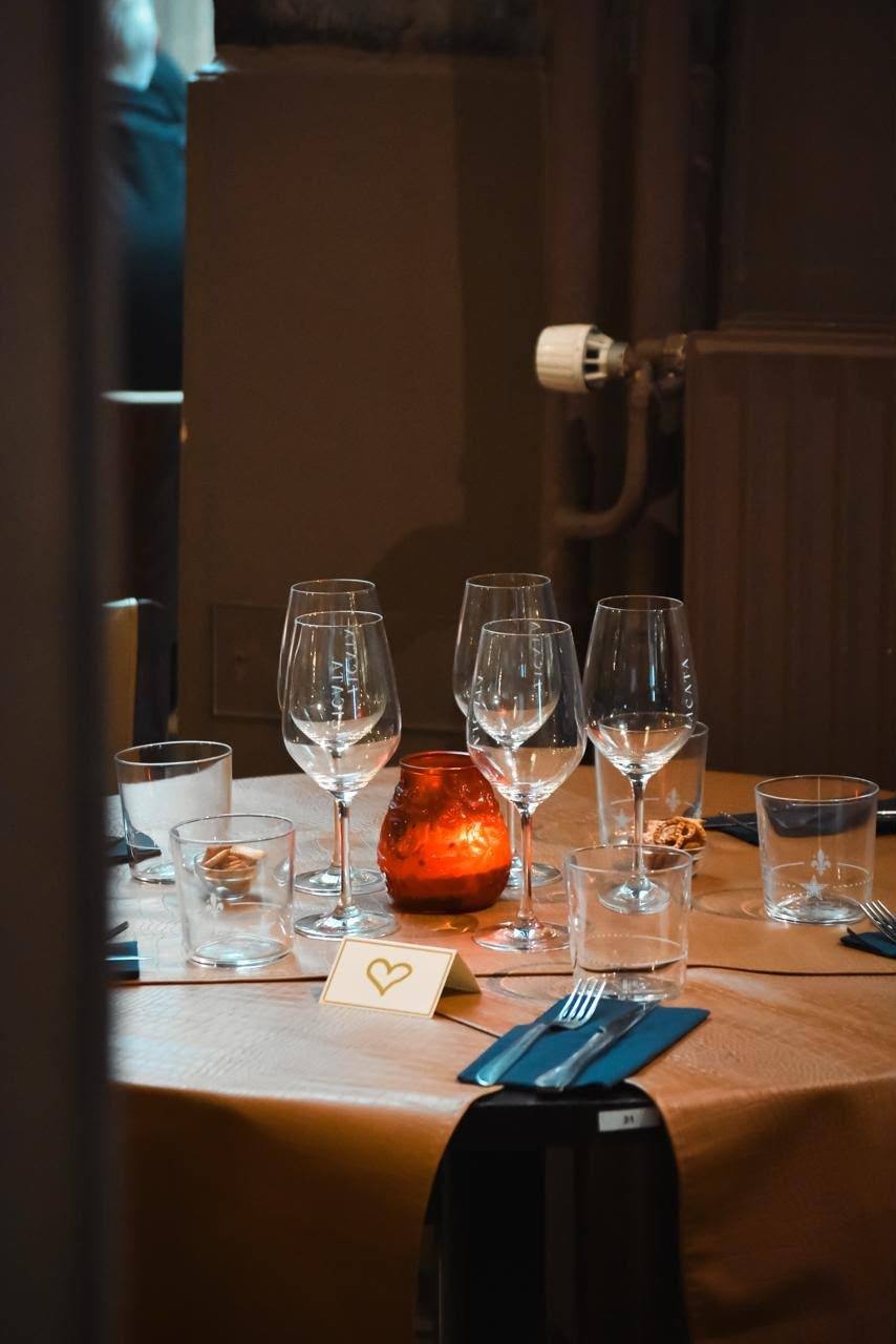 Une table dressée avec verres et bougie, prête pour le service du soir